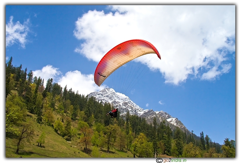 Paragliding over snow covered peaks at Solang valley of Manali