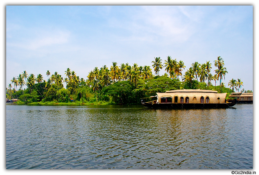 Houseboat and coconut tree by the side of river