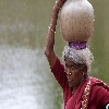 Old woman carrying two water pots