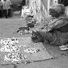 Old woman with lot of coins paisa and empty bowls of beggers