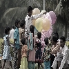 Balloon vendor in park children purchasing