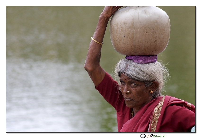 Old woman carrying two water pots