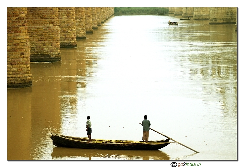 Two people on a boat in dobhi ghat river Godavari in Rajahmundri