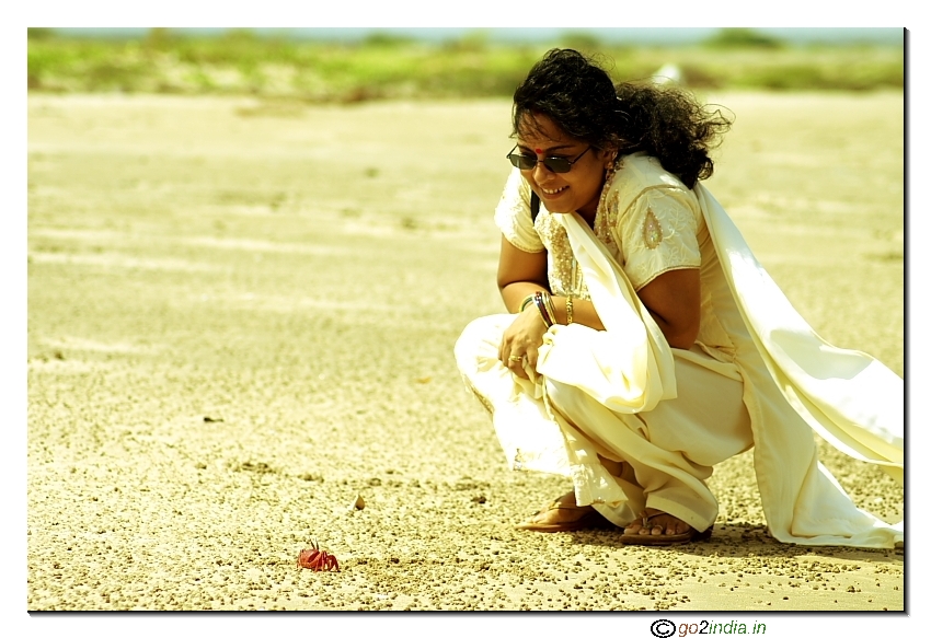 A visitor looking at a crab in Antarvedi of Vasishta Godavari in Andhrapradesh