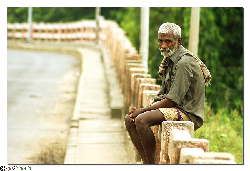 Old village man sitting over a bridge in rural Andhrapradesh of India