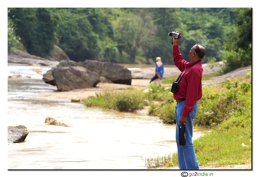 Person taking video near a river