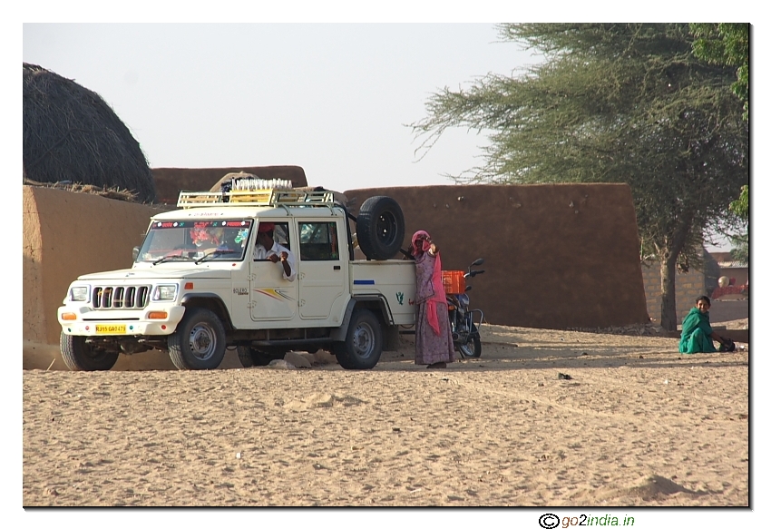 A vehicle in a village inside desert. Taking villages to Jaisalmer 