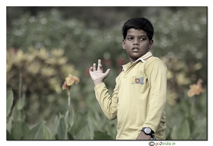 A boy posing for photograph in a park