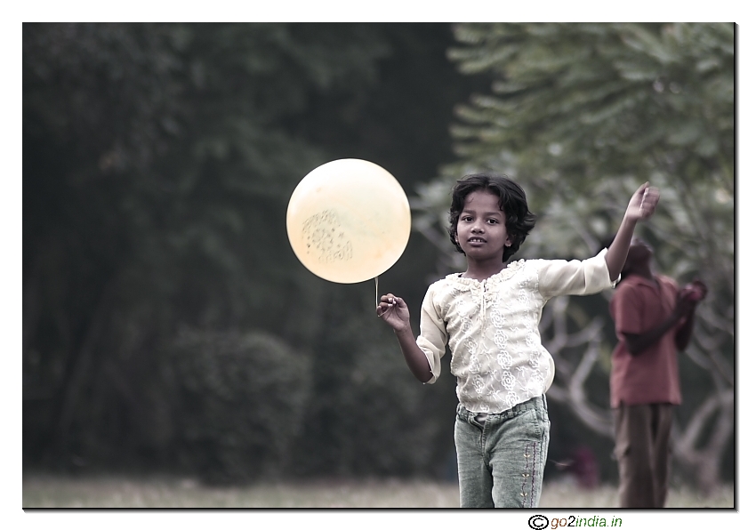 girl holding balloon playing desaturated colours