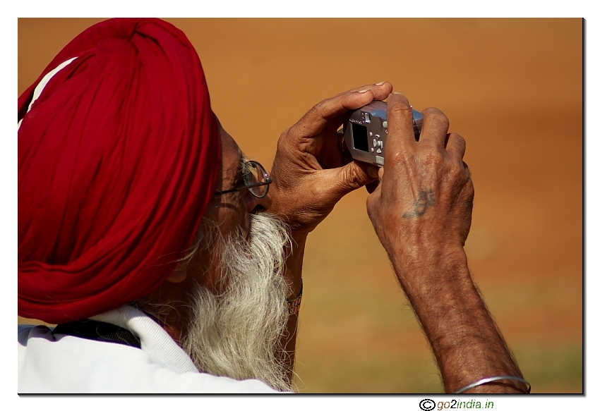 Old man taking photo using P & S camera
