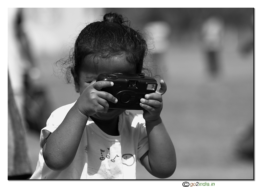 Small kid taking photo using P & S film camera