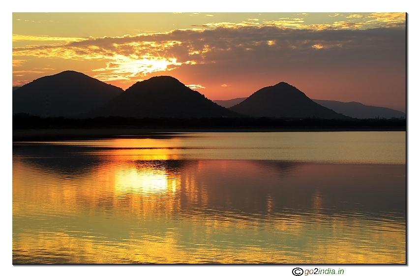 Sun set reflection at water with shining cloud formation