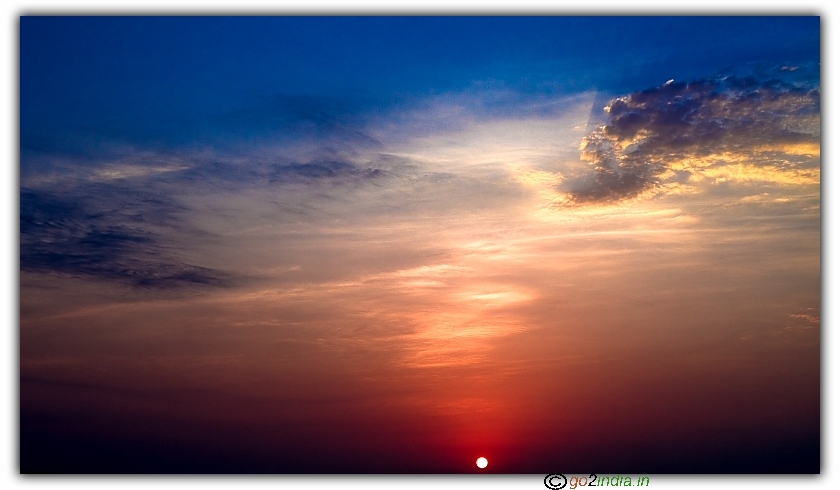 Red Sun rise with blue sky yellow clouds