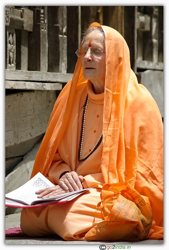 foreign lady dressed in Hindu tradition performing dhyana in a temple