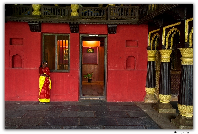 Old woman standing inside an old palace