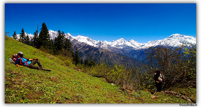 Trekker resting while enjoying the Himalayan snow covered peaks