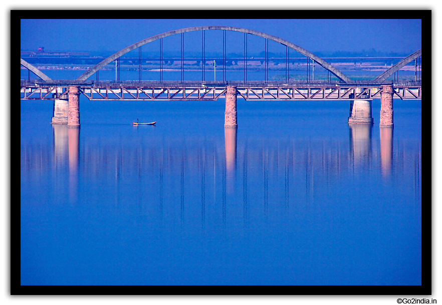 Blue water and the Arc of rail bridge at Rajahumndry